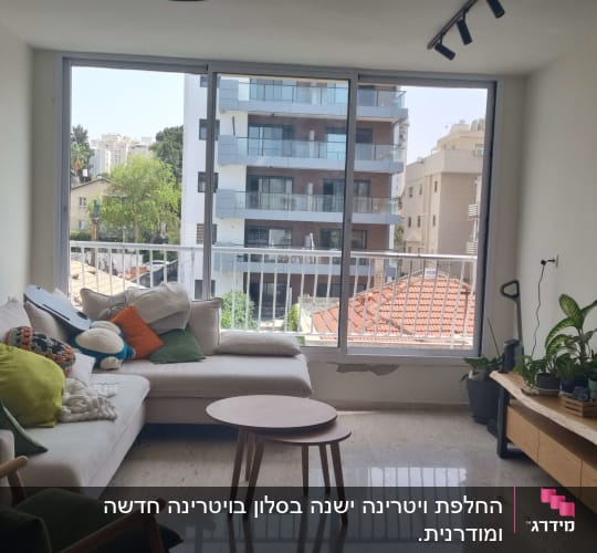 סלון עם חלון גדול ונוף לבניינים